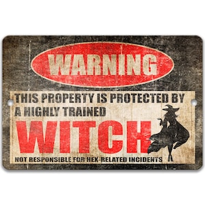 May include: A rectangular metal sign with a distressed finish featuring a red oval with the text WARNING. Below, the text reads THIS PROPERTY IS PROTECTED BY A HIGHLY TRAINED WITCH, with the word WITCH in large red letters and a black witch silhouette.