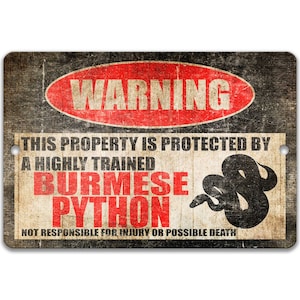 Op de afbeelding: Een waarschuwingsbord met een rode cirkel en het woord "WARNING" in witte letters. Het bord luidt "This property is protected by a highly trained Burmese Python. Not responsible for injury or possible death."