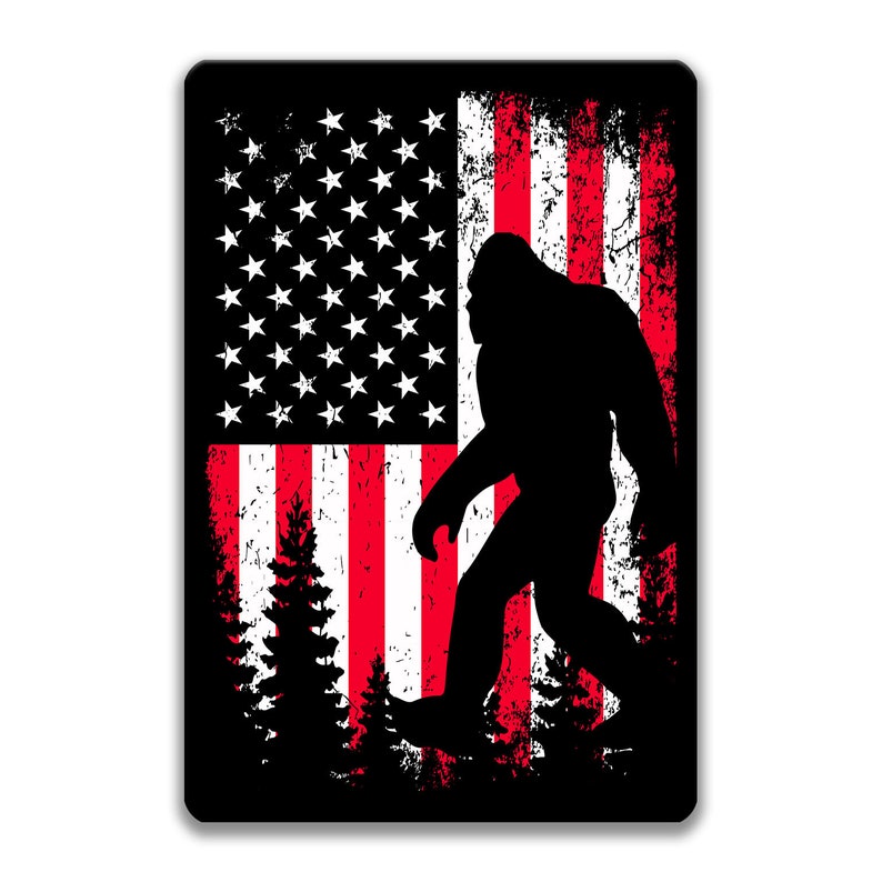 Puede incluir: Una silueta negra de Bigfoot de pie frente a una bandera estadounidense desgastada con rayas rojas y blancas y estrellas blancas sobre un campo azul.