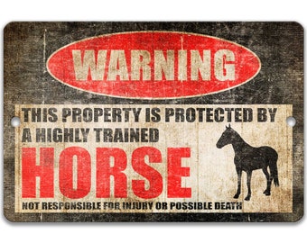 May include: A black and white warning sign with red text that reads "WARNING" in a circle. The sign says "This property is protected by a highly trained HORSE. Not responsible for injury or possible death." A black silhouette of a horse is in the bottom right corner.