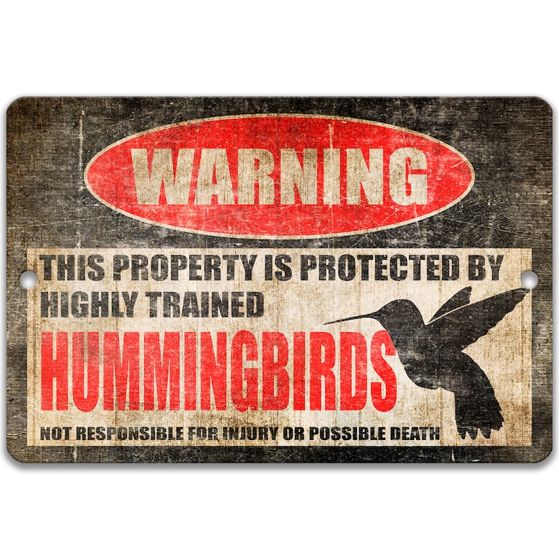 Puede incluir: Un cartel de advertencia con un c&iacute;rculo rojo y la palabra "WARNING" en blanco. El cartel dice "This property is protected by highly trained hummingbirds. Not responsible for injury or possible death."