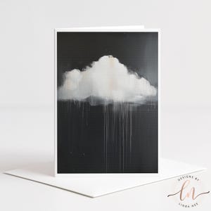 Puede incluir: Tarjeta de felicitación con una pintura abstracta de una nube blanca sobre un fondo gris oscuro. La nube tiene pinceladas texturizadas y líneas blancas verticales que sugieren lluvia. La tarjeta está en un marco blanco, con un sobre blanco.