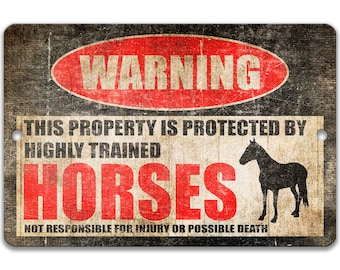 May include: A rectangular metal sign with a distressed, vintage appearance. The sign displays the word "WARNING" in a red oval, and text stating "THIS PROPERTY IS PROTECTED BY HIGHLY TRAINED HORSES." A black horse silhouette is on the right.
