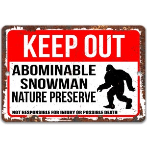 May include: A red and white metal sign with the text "KEEP OUT" in large white letters. Below the text is the phrase "ABOMINABLE SNOWMAN NATURE PRESERVE" in black letters. A black silhouette of a large, hairy creature walking is to the right of the text. The bottom of the sign reads "NOT RESPONSIBLE FOR INJURY OR POSSIBLE DEATH" in smaller black letters.