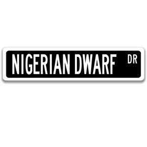 May include: Black and white street sign with the text "NIGERIAN DWARF DR" in white.