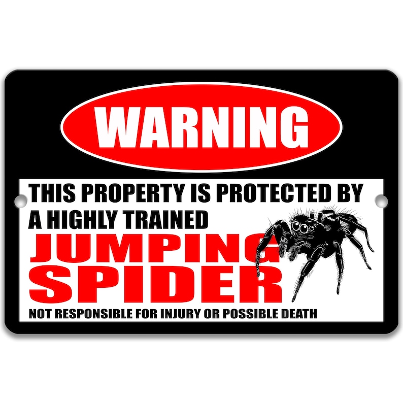 May include: Black rectangular sign with the word "WARNING" in a red oval. Text below reads "THIS PROPERTY IS PROTECTED BY A HIGHLY TRAINED JUMPING SPIDER" with a graphic of a black spider. The bottom text says "NOT RESPONSIBLE FOR INJURY OR POSSIBLE DEATH."