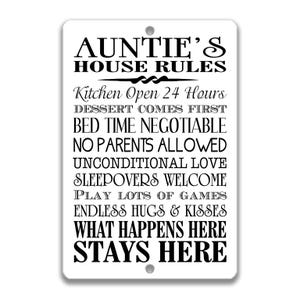 Puede incluir: Letrero rectangular blanco con texto negro, que dice "AUNTIE'S HOUSE RULES". El letrero enumera reglas como "Kitchen Open 24 Hours" y "What Happens Here Stays Here".