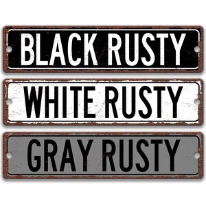 three signs with the text "BLACK RUSTY WHITE RUSTY GRAY RUSTY" written on them.