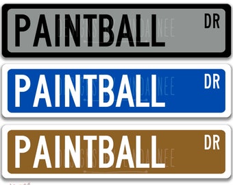 May include: Three aluminum signs, each 4 x 18 inches, with the word "PAINTBALL" in bold white letters. The top sign is gray, the middle is blue, and the bottom is brown. All have "DR" in the corner.