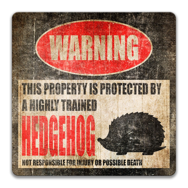 May include: A red and black warning sign with the text "WARNING" in a red oval. The sign says "This property is protected by a highly trained hedgehog. Not responsible for injury or possible death." The sign has a distressed, vintage look.