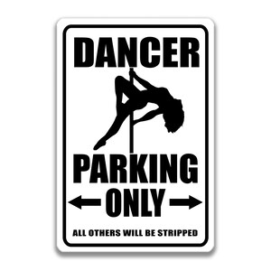 May include: A white sign with black text and a silhouette of a woman on a pole. The sign reads "Dancer Parking Only. All others will be stripped."