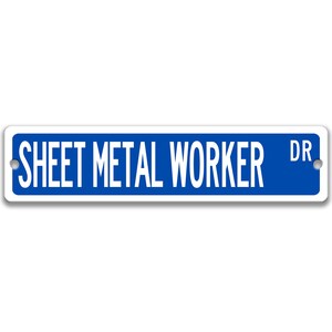 May include: A rectangular blue sign with white text reading "SHEET METAL WORKER DR". The sign has a white border and two pre-drilled holes for mounting.