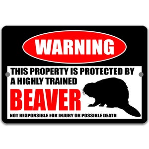 May include: A black and red warning sign with the text "WARNING" in a red oval. The text "THIS PROPERTY IS PROTECTED BY A HIGHLY TRAINED BEAVER" is in white text on a black background. The text "NOT RESPONSIBLE FOR INJURY OR POSSIBLE DEATH" is in white text on a black background. A black silhouette of a beaver is shown in the lower right corner of the sign.