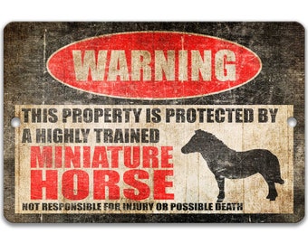 May include: A warning sign with a red circle and the word "WARNING" in white letters. The sign reads "This property is protected by a highly trained miniature horse. Not responsible for injury or possible death." The sign has a distressed, vintage look and features a silhouette of a miniature horse.