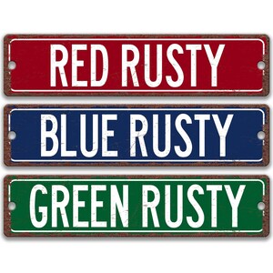 three signs with the text "RED RUSTY BLUE RUSTY GREEN RUSTY" written on them.