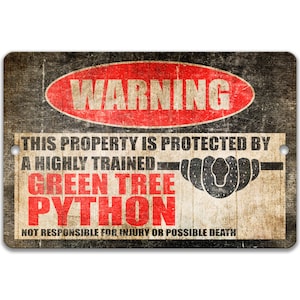 May include: A rectangular metal sign with a distressed, vintage appearance. The sign displays the word "WARNING" in a red oval, and text stating "THIS PROPERTY IS PROTECTED BY A HIGHLY TRAINED GREEN TREE PYTHON". The sign warns "NOT RESPONSIBLE FOR INJURY OR POSSIBLE DEATH".