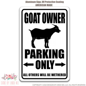 K&ouml;nnte beinhalten: Ein wei&szlig;es Metallschild mit schwarzem Text und einer schwarzen Silhouette einer Ziege. Das Schild lautet "Goat Owner Parking Only - All Others Will Be Wethered".