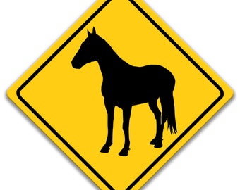 May include: A yellow diamond-shaped warning sign with a black silhouette of a horse. The sign is used to warn drivers of horses on the road.