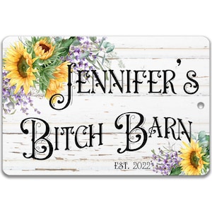 May include: White wooden sign with a distressed finish featuring a sunflower and lavender floral design. The sign reads "Jennifer's Bitch Barn Est. 2022".