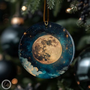 May include: Round Christmas ornament featuring a full moon against a starry night sky. The moon is a warm, golden color, surrounded by a deep blue and teal background with white clouds. The ornament has a gold string for hanging.