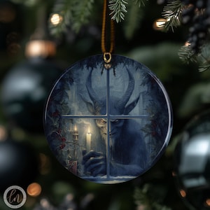 May include: Round Christmas ornament featuring a horned creature holding a candle in a window. The artwork is in shades of blue and gray, with a gold hanging loop. The ornament has a dark, gothic theme.