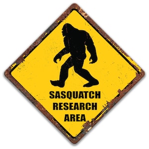 Signo del área de investigación de Sasquatch, signo de Sasquatch de precaución amarilla, letrero de estaño oxidado, decoración vintage de pie grande, signo de Sasquatch divertido, cabina 8-ANM009