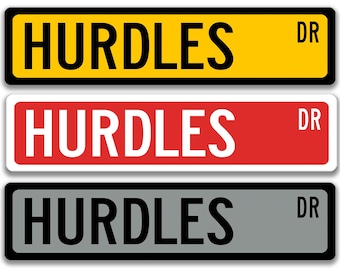 Puede incluir: Tres señales de tráfico con la palabra "HURDLES" en letras blancas y en negrita. La señal superior es amarilla con un borde negro, la señal del medio es roja con un borde blanco y la señal inferior es gris con un borde negro. Cada señal tiene "DR" en la esquina.