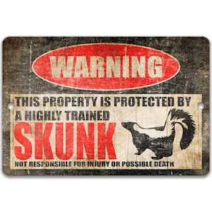 May include: A warning sign with a distressed, vintage look. It reads "WARNING" in a red circle with a black border. The text below reads "THIS PROPERTY IS PROTECTED BY A HIGHLY TRAINED SKUNK. NOT RESPONSIBLE FOR INJURY OR POSSIBLE DEATH." A black and white silhouette of a skunk is shown in the center of the sign.