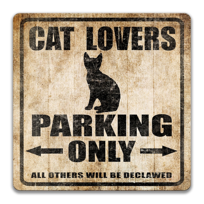 Pu&ograve; includere: Un cartello in stile vintage con uno sfondo marrone rovinato e testo nero. Il cartello recita "Cat Lovers Parking Only" con una freccia che punta a sinistra e una freccia che punta a destra. Sotto il testo c'&egrave; una silhouette di un gatto seduto. Il cartello recita anche "All Others Will Be Declawed".
