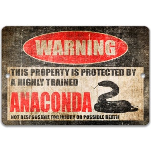 May include: A black and red warning sign with the text "WARNING" in a red circle. The text "THIS PROPERTY IS PROTECTED BY A HIGHLY TRAINED ANACONDA" is in black text. A black silhouette of a snake is in the bottom right corner. The text "NOT RESPONSIBLE FOR INJURY OR POSSIBLE DEATH" is in black text at the bottom.