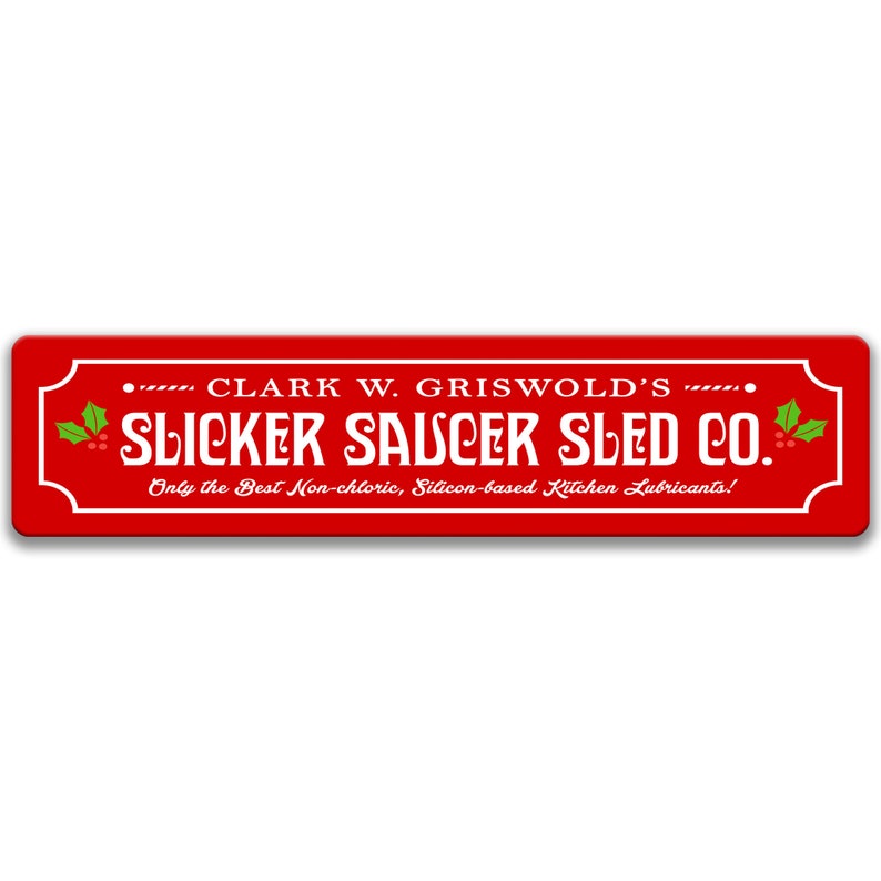 Puede incluir: Un letrero rojo con texto blanco que dice "Clark W. Griswold's Slicker Saucer Sled Co. Only the Best Non-chloric, Silicon-based Kitchen Lubricants!" El letrero tiene una rama de acebo con bayas rojas a cada lado.