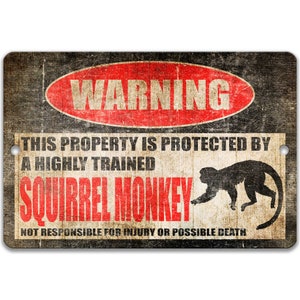 May include: A warning sign with a distressed, vintage look. It reads "WARNING" in a red circle with white text. The sign says "This property is protected by a highly trained squirrel monkey. Not responsible for injury or possible death."