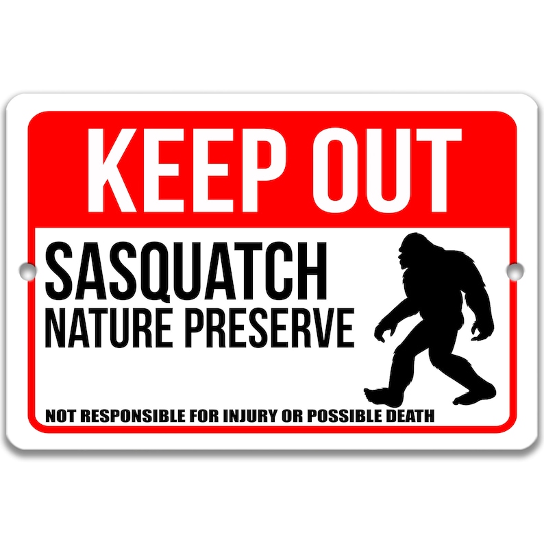 Op de afbeelding: Een wit bord met rode letters met de tekst "KEEP OUT" en "SASQUATCH NATURE PRESERVE". Een zwart silhouet van een sasquatch loopt naar rechts. Onderaan het bord staat "NOT RESPONSIBLE FOR INJURY OR POSSIBLE DEATH."
