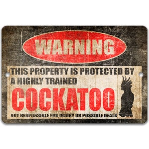 Puede incluir: Un letrero metálico rectangular con un aspecto vintage y desgastado. El letrero presenta la palabra "WARNING" en un óvalo rojo, y el texto "THIS PROPERTY IS PROTECTED BY A HIGHLY TRAINED COCKATOO". Una silueta de cacatúa está a la derecha.