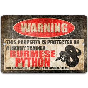 K&ouml;nnte beinhalten: Ein Warnschild mit einem roten Kreis und dem Wort "WARNING" in wei&szlig;en Buchstaben. Das Schild lautet "This property is protected by a highly trained Burmese Python. Not responsible for injury or possible death."