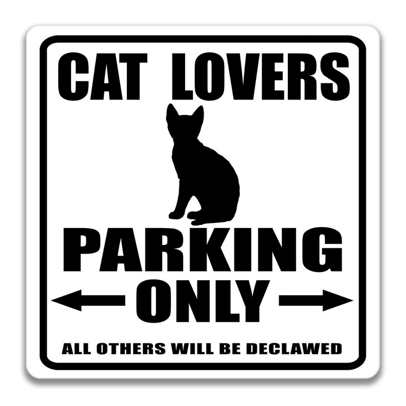 Pu&ograve; includere: Un cartello bianco e nero con il testo "Cat Lovers Parking Only" e una silhouette di un gatto. Il testo "All others will be declawed" &egrave; sotto il testo principale.