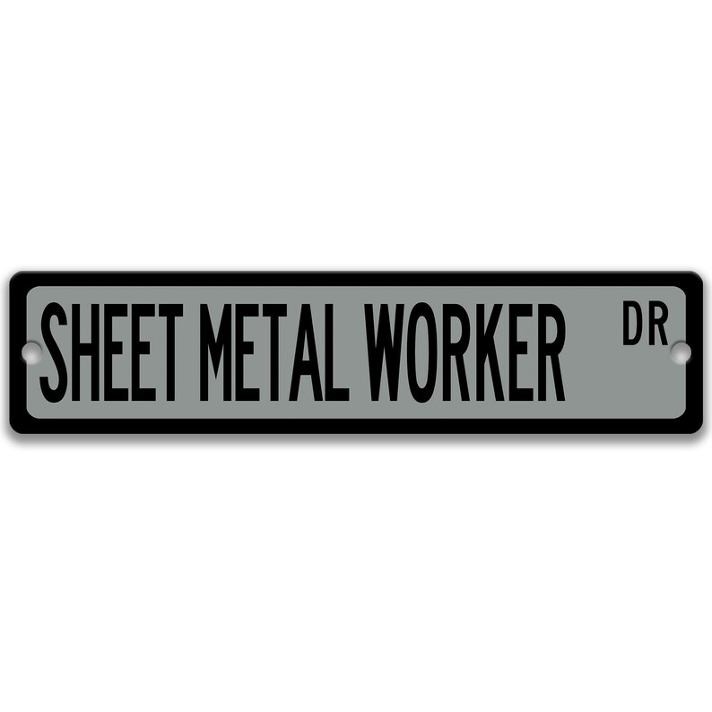 May include: A rectangular street sign with the words "SHEET METAL WORKER DR" in black capital letters on a grey background. The sign has a black border and two silver mounting holes.