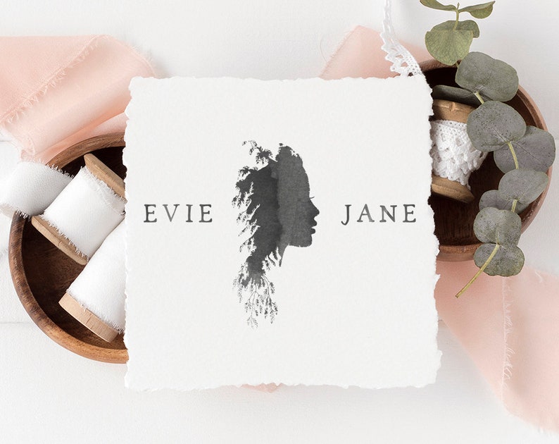 May include: A white card with a black silhouette of a woman's face with a tree design. The text "EVIE JANE" is printed on the card.