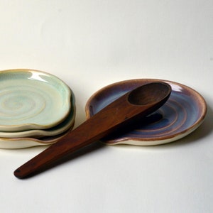 May include: A distressed white wooden sign displaying the word "Welcome" in a handwritten font. A small heart decoration is affixed below the text. The background is a blurred wooden texture, suggesting a rustic aesthetic.