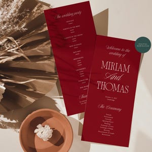 May include: Two deep red wedding program cards featuring white serif and script typography. The text includes "Welcome to the wedding of MIRIAM AND THOMAS", "October 13, 2027", "The Ceremony", and "The wedding party". A small circular teal "DIGITAL DOWNLOAD" badge is visible.