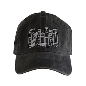 May include: A black baseball cap with a white embroidered design of a stack of books.