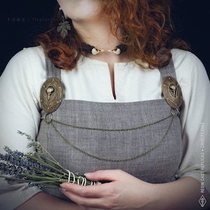 Two hand painted brass brooches with a bird crow skull design, connected by two bronze chains. This pins are perfect for historical reenactments, cosplay, Viking and Norse style costumes. Medieval wedding dress.
