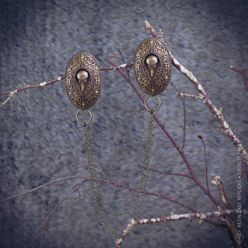 Two hand painted bronze brooches with a bird crow skull design, connected by two bronze chains. This pins are perfect for historical reenactments, cosplay, Viking and Norse style costumes. Medieval wedding dress.
