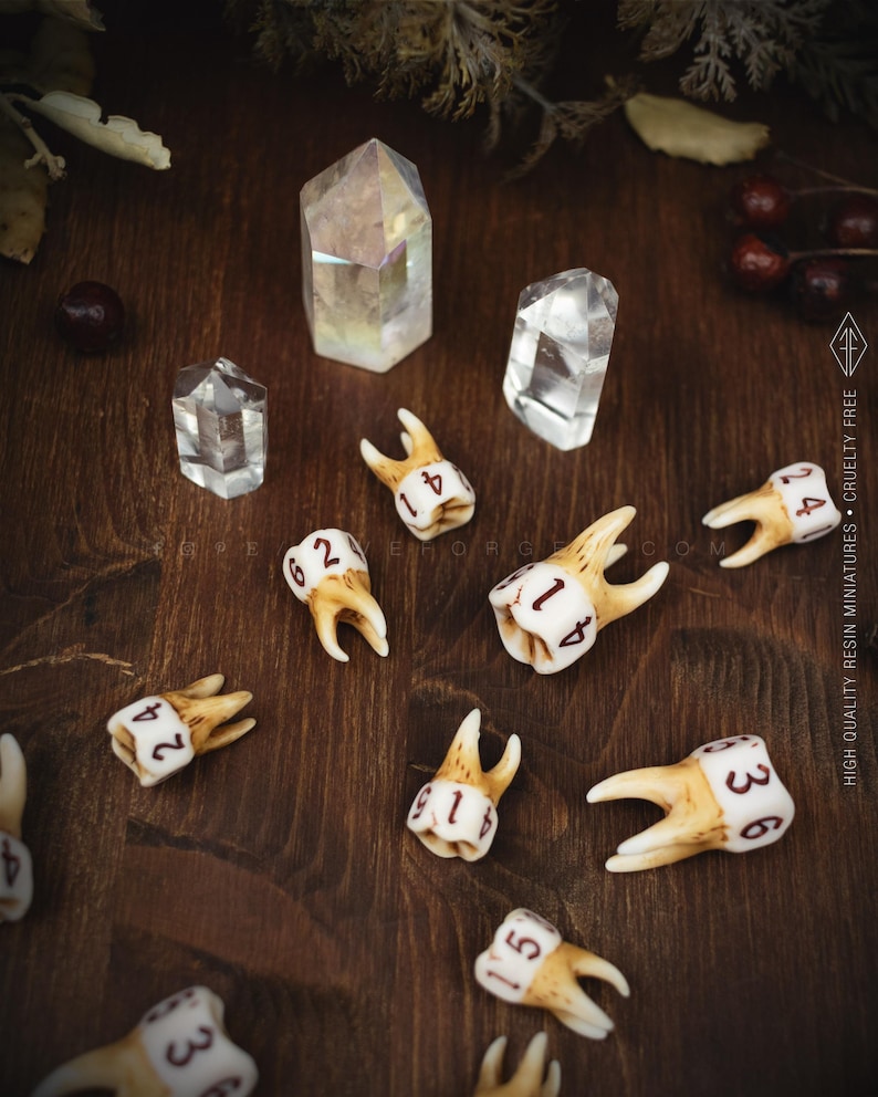 A collection of realistic molar tooth dice scattered on a dark wooden table next to clear quartz crystals, showing different sides and roots of the teeth.