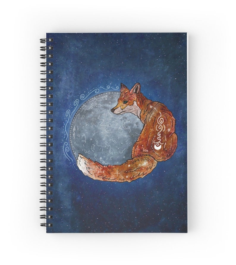 May include: Spiral-bound notebook featuring a watercolor illustration of a fox curled around a moon. The fox is reddish-brown with white markings, set against a dark blue starry background. The moon is a pale gray with constellations.