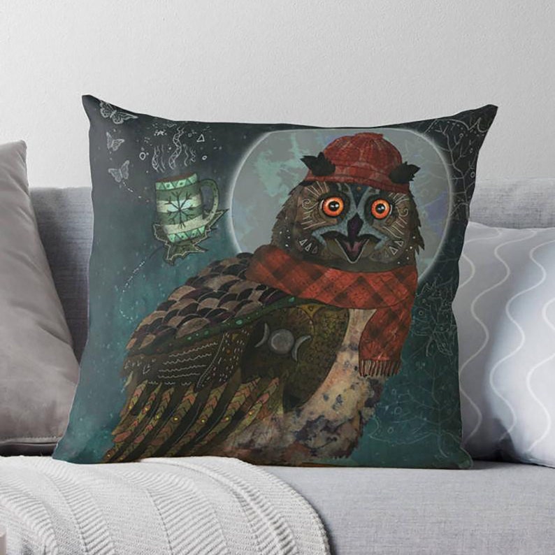 May include: Decorative throw pillow featuring a whimsical owl illustration. The owl is adorned with a red hat and scarf, set against a dark blue background with a full moon and a steaming mug. The owl's feathers are detailed with intricate patterns.