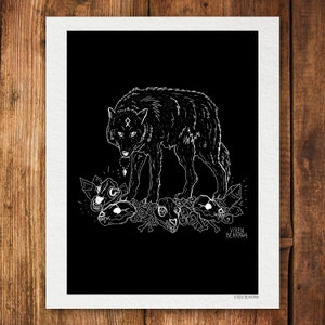 May include: A black and white line art print of a wolf standing on a pile of bones. The wolf has a symbol on its forehead and is looking down at the bones. The print is signed "Vixen Bergman" in the bottom right corner.