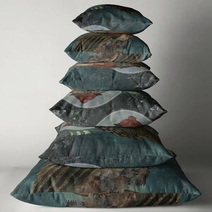 May include: A stack of six decorative throw pillows. The pillows have a dark teal background with a detailed, artistic design featuring brown, red, and white elements. The design appears to be a landscape or abstract pattern.