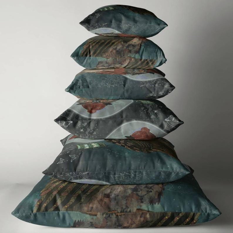 May include: A stack of six decorative throw pillows. The pillows have a dark teal background with a detailed, artistic design featuring brown, red, and white elements. The design appears to be a landscape or abstract pattern.