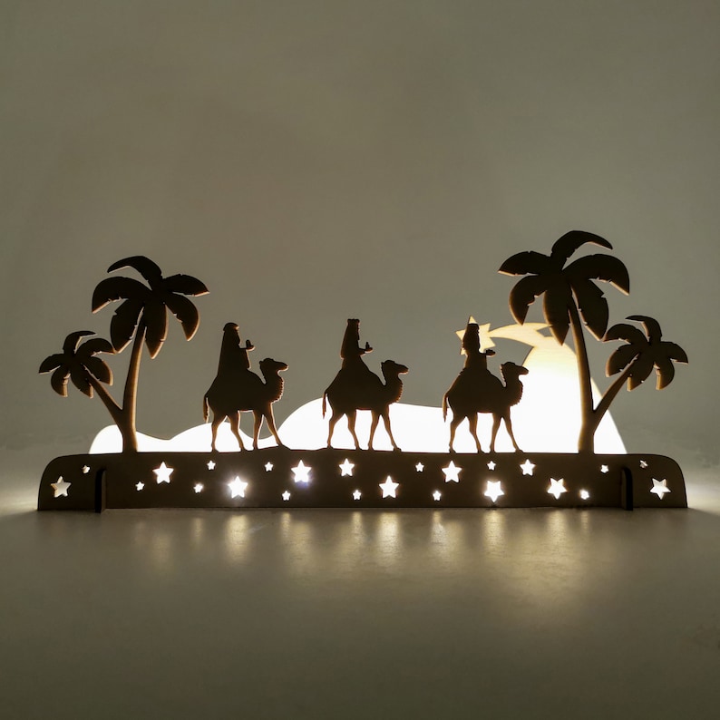 Christmas decoration - three wise kings laser cut. This is the scene where the three wise men bring gifts to the baby Jesus. The decoration was photographed in the dark with lighting inside the decoration.